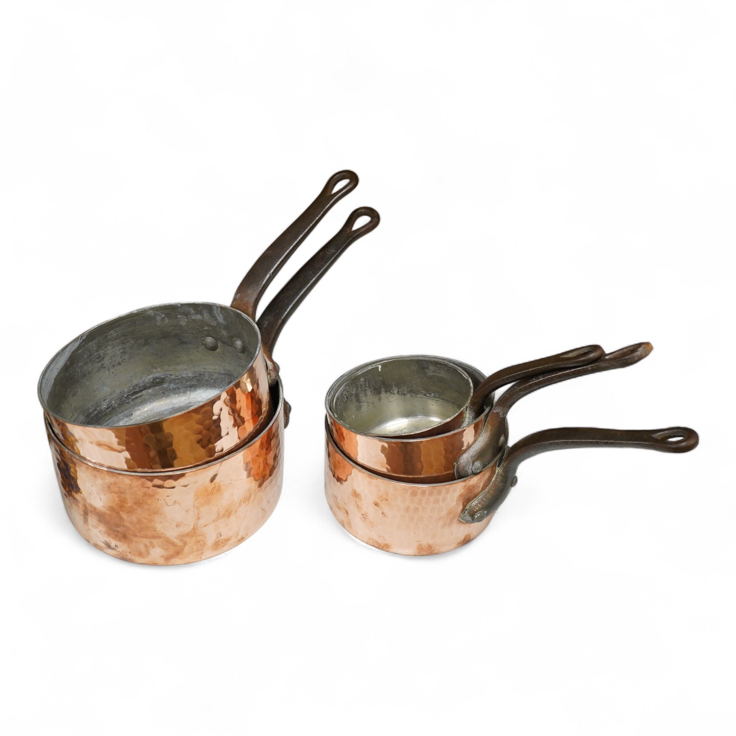 A set of five graduated hammered copper saucepans, largest 37cm in length